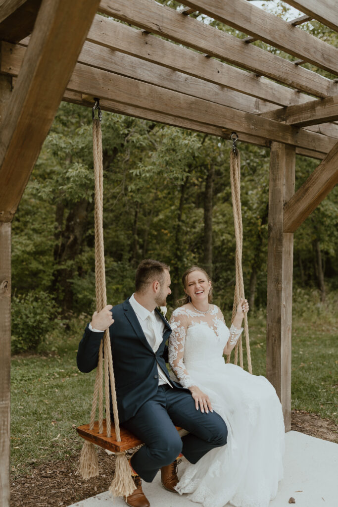 bride and groom portraits on a swing after wedding ceremony